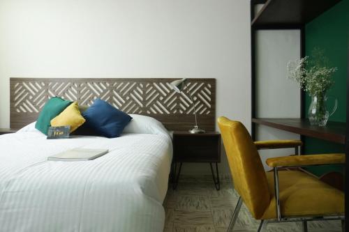 a bedroom with a bed and a desk and a chair at The Dear in Puebla
