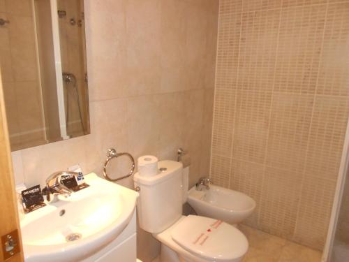 y baño con aseo blanco y lavamanos. en Hostal Ca La Irene, en Sant Vicenç de Castellet