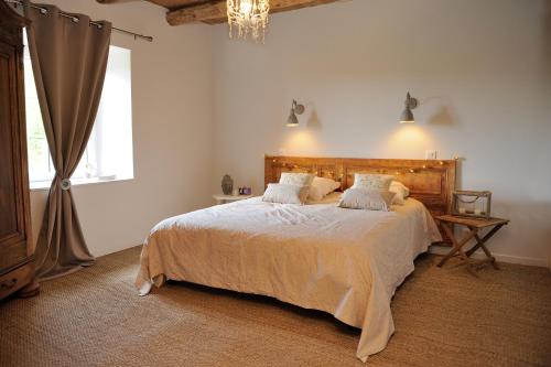 een slaapkamer met een groot bed en een raam bij Suite privative sur Domaine Au chant de l'eau avec possibilité séjour bien-être in Siaugues Ste Marie