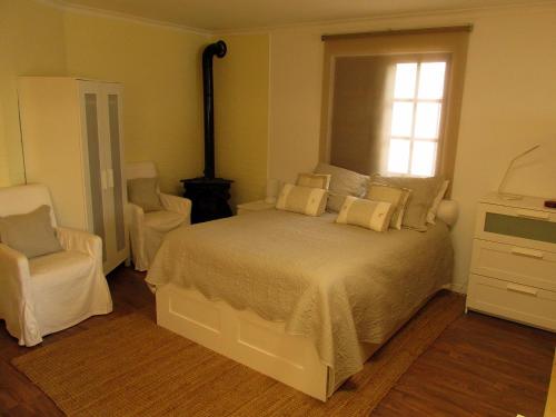 a bedroom with a bed and a chair and a window at Go PT - Private challet with swimming pool and garden in Parede