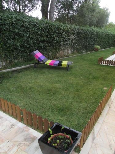 a garden with a umbrella laying on the grass at Go PT - Private challet with swimming pool and garden in Parede