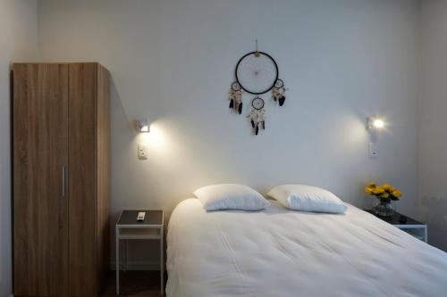 a bedroom with a bed with two pillows and a clock at Alpha Hotel and Aparthotel in Tienen