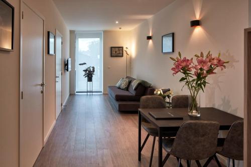 een woonkamer met een tafel en een bank bij Alpha Hotel and Aparthotel in Tienen