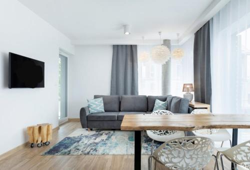 a living room with a couch and a table at Sailor 7 Z bocznym widokiem na morze in Ustronie Morskie