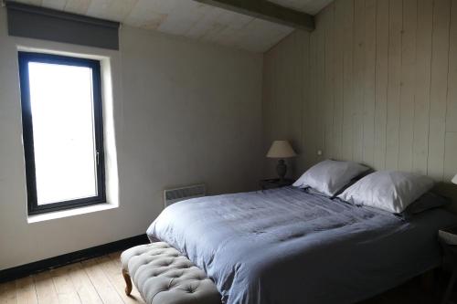 a bedroom with a large bed and a window at Magnifique rétaise-hyper centre le Bois-Plage-en-Ré in Le Bois-Plage-en-Ré