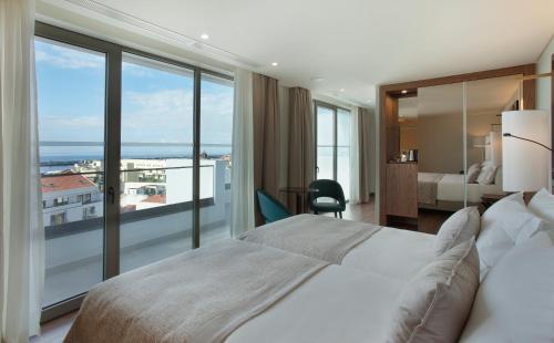 ein Hotelzimmer mit einem Bett und einem großen Fenster in der Unterkunft TURIM Santa Maria Hotel in Funchal