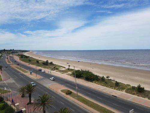a road next to a beach with the ocean at Cottage Carrasco in Montevideo
