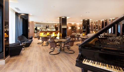 a lobby with a piano and chairs and a bar at TURIM Santa Maria Hotel in Funchal