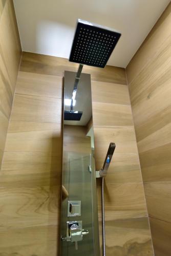 a bathroom with a shower with a ceiling light at Delmare Beachfront Bangsaray Premium Condominium in Bang Sare