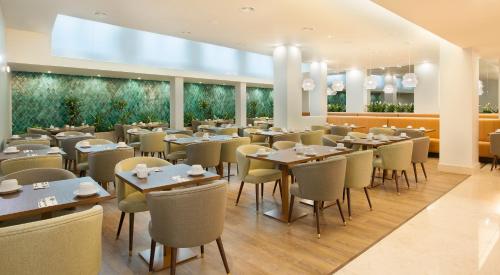 a dining room with tables and chairs in a restaurant at TURIM Santa Maria Hotel in Funchal