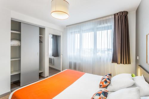 a bedroom with a large bed and a window at Appart'City Confort Amiens Gare in Amiens