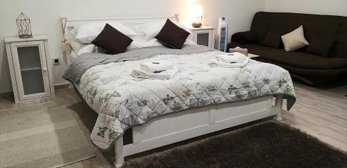 a bedroom with a bed with a blanket and a couch at Huncovská 14 in Košice