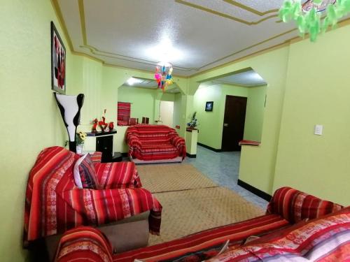 a living room with two couches and a room at Hostal y Complejo Recreacional La Playita de Monse in Otavalo