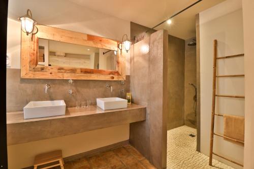 a bathroom with two sinks and a shower at Le Mas Des Brune in Saint-Laurent-dʼAigouze