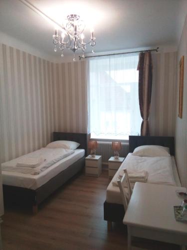 a bedroom with two beds and a chandelier at Liahof in Ullared