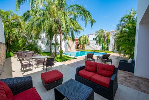 eine Terrasse mit einem Tisch, Stühlen und einem Pool in der Unterkunft Hotel Embajadores in Mérida