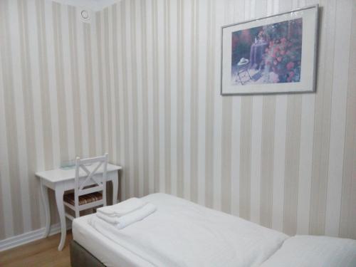 a bedroom with a bed and a table and a picture at Liahof in Ullared