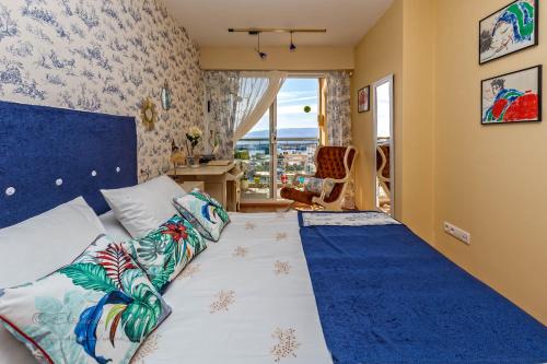 1 dormitorio con 1 cama con cabecero azul y ventana en Noia Compostellae Beach, en Portosín