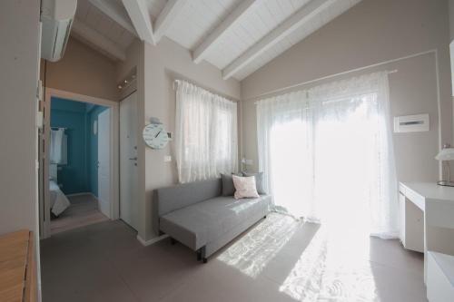 een woonkamer met een bank en een raam bij Giardino di Annabella-giardino privato-posto auto in Bologna