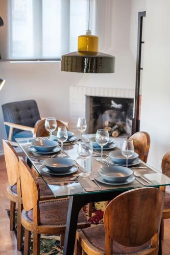 a dining room table with glasses and plates on it at BABhouse Casa da Colmeia - Coração do Douro in São João da Pesqueira
