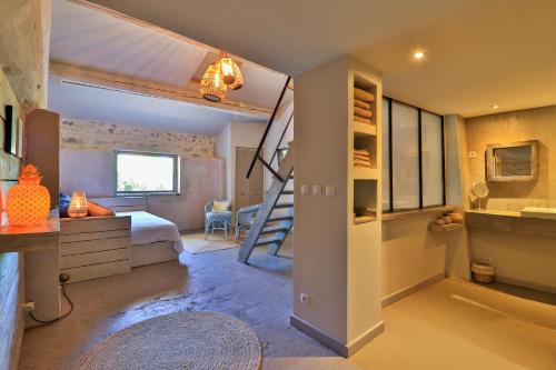 a bedroom with a bunk bed and a staircase in it at Le Mas Des Brunes in Saint-Laurent-dʼAigouze