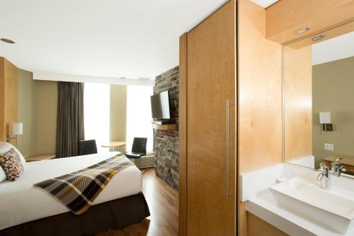 a hotel room with a bed and a sink at Hotel du Vieux Quebec in Quebec City