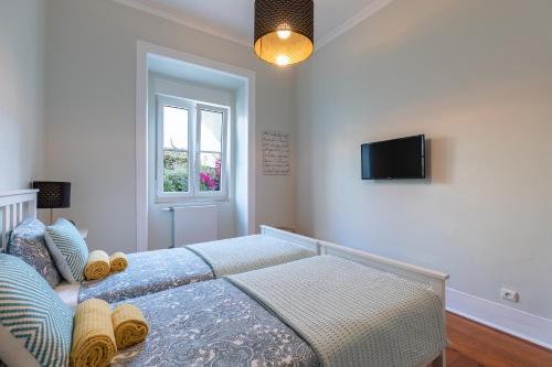 a bedroom with a bed and a tv on the wall at Graça Palace with Private Pool Garden in Lisbon