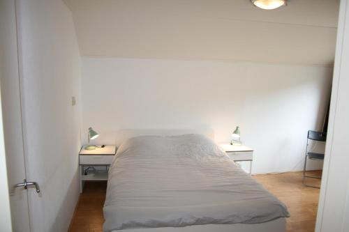 a bedroom with a bed and two night stands at vakantiewoning grensgebied Groningen/Drenthe/Friesland in Zevenhuizen