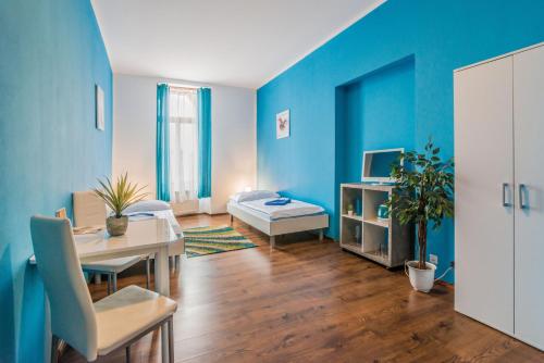 a living room with a table and a blue wall at Penzión TIME in Prešov