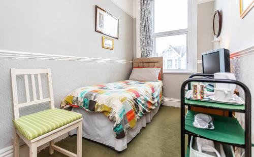 a small bedroom with a bed and a chair at The Ravensbourne Hotel in Bournemouth