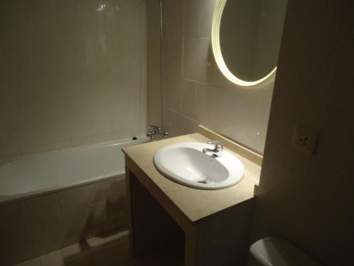 a bathroom with a sink and a tub and a mirror at Residencial Itxaso 4/6 LEK in Peñíscola