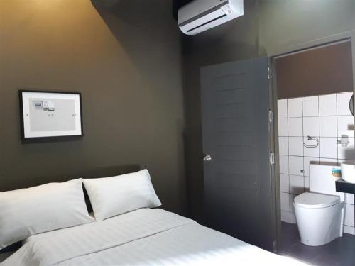 a bedroom with a white bed and a bathroom at Capsule Hostel Chiangkhan in Chiang Khan