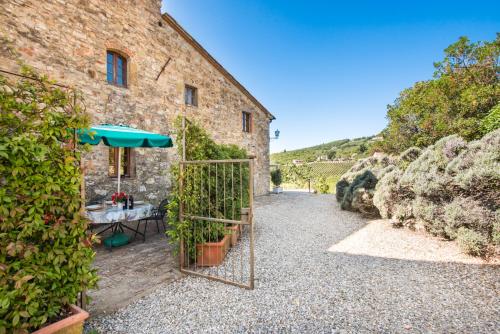 a door to a building with a table and an umbrella at Agriturismo La Ferrozzola in Castellina in Chianti
