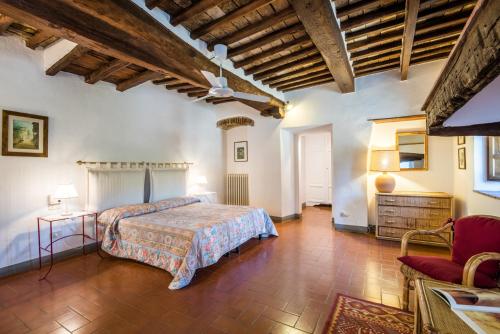 a bedroom with a bed and a chair in a room at Agriturismo La Ferrozzola in Castellina in Chianti