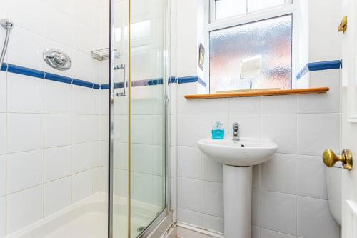 a bathroom with a sink and a shower at The Ravensbourne Hotel in Bournemouth
