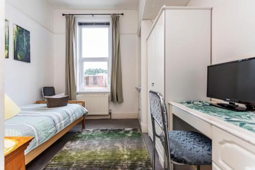 a small room with a bed and a television at The Ravensbourne Hotel in Bournemouth
