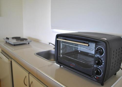 a black toaster oven sitting on top of a kitchen counter at La Fleur in Villa General Belgrano