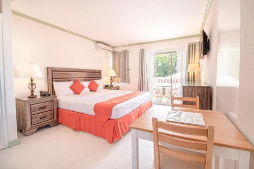 um quarto com uma cama, uma mesa e uma secretária em Worthing Court Apartment Hotel em Bridgetown