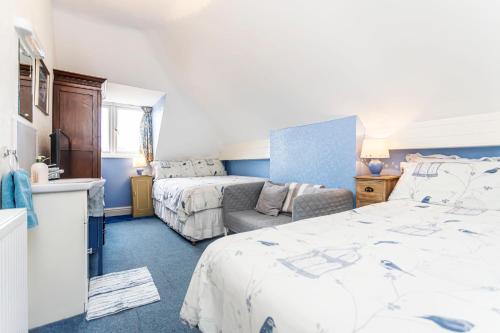 a bedroom with two beds and a couch at The Ravensbourne Hotel in Bournemouth