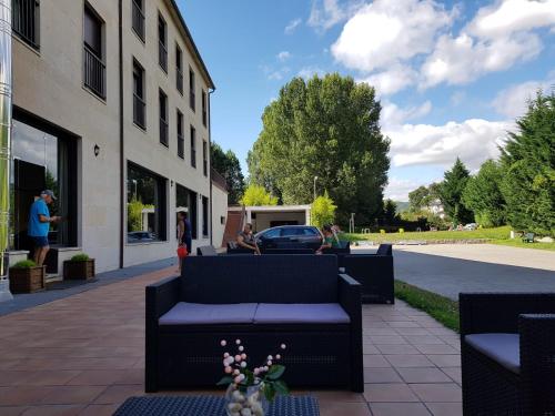 patio z kanapami poza budynkiem w obiekcie Hotel AV Apartamentos Lobios w mieście Lobios