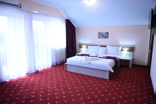 Habitación de hotel con cama y alfombra roja en Vila Elysee en Baile Felix