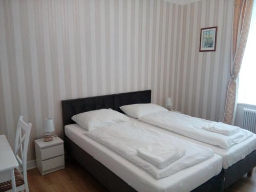 a bedroom with a bed with white sheets and pillows at Liahof in Ullared