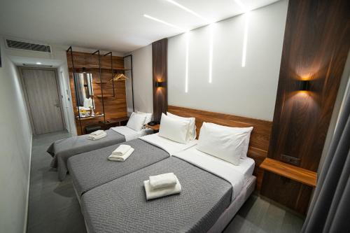 a hotel room with two beds and two nightstands at Argo Hotel Piraeus in Piraeus