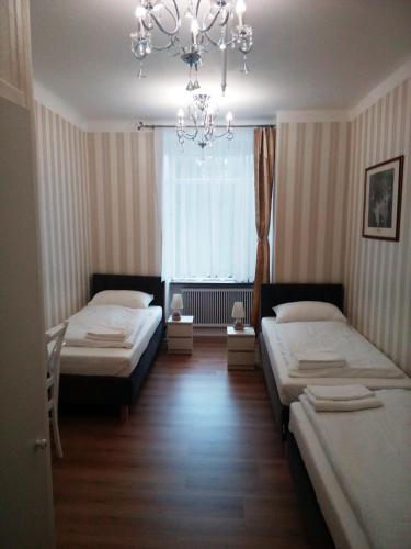 a bedroom with two beds and a chandelier at Liahof in Ullared