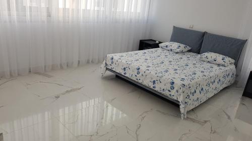 a bedroom with a bed in a room with marble floors at Mobina Villas in Larnaka