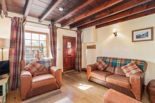 a living room with two couches and a television at The Cottage Gillamoor in Gillamoor