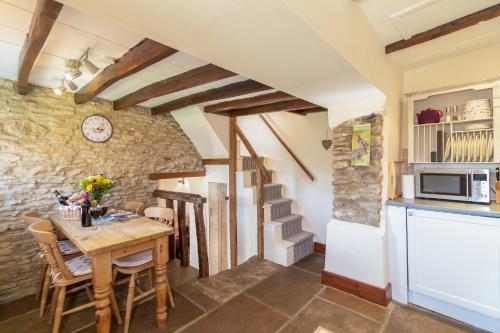 a kitchen and dining room with a wooden table at The Cottage Gillamoor in Gillamoor