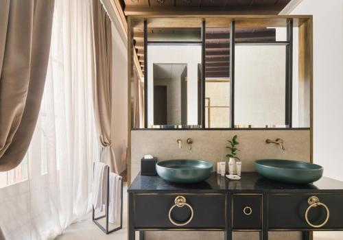 a bathroom with two sinks in front of a mirror at Hotel Antigua Palma - Casa Noble in Palma de Mallorca