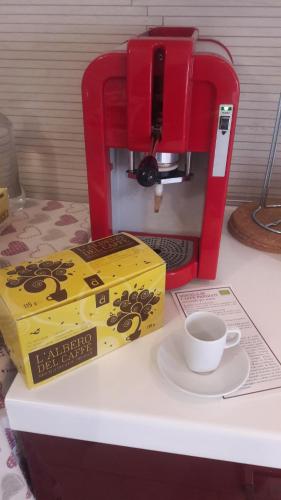 a coffee machine with a box and a cup on a counter at Corte San Petronio in Castagnolo