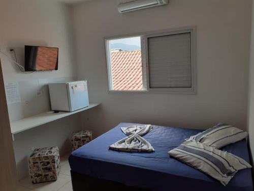 a bedroom with a blue bed with a window at Sol Mar Pousada in Praia Grande